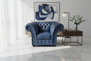 Blue armchair in a modern living room with abstract art and a side table.