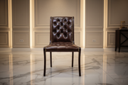 Brown leather chair in a room with marble flooring and paneled walls.