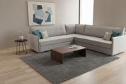 Gray sectional sofa in a living room with a coffee table and decorative items.