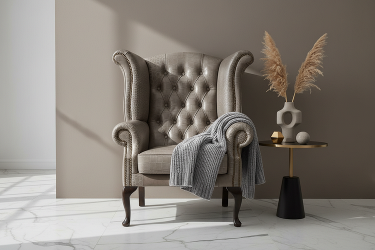 Gray armchair with a blanket in a room with a side table and decorative elements.